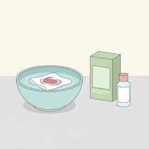 ظرف آب که یک پارچه یا لباس درون آن در حال خیساندن است و یک اب اکسیژنه کنار آن است